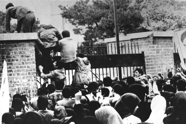 Iranian students climb over the wall of the US embassy in Tehran